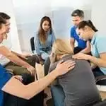 stock image of a group of people comforting a young lady