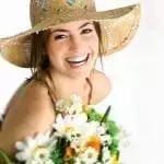 smiling women with a sun hat and a bouquet of flowers