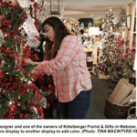 lady decorating a christmas tree at Kittleberger Florist and Gifts