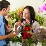 stock image of asian women in a flowershop helping a caucasion male customer