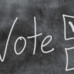 the word vote written on a chalk board with two boxes to check off