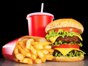 stacked cheeseburger, fries and a drink representing fast food