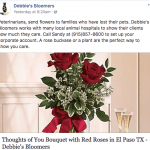 two red roses in a vase on a table and you cans see to champagne glasses