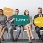 stock image of several people holding signs for a survey