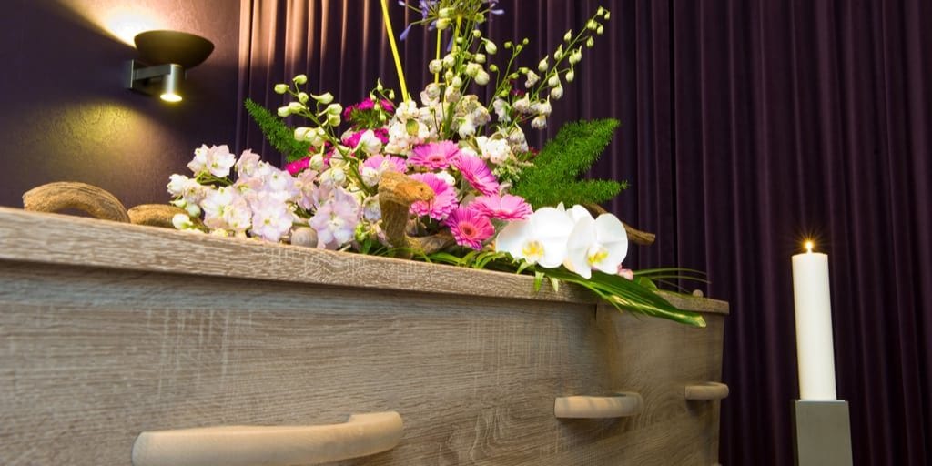 coffin with pink and white flowers at a funeral home