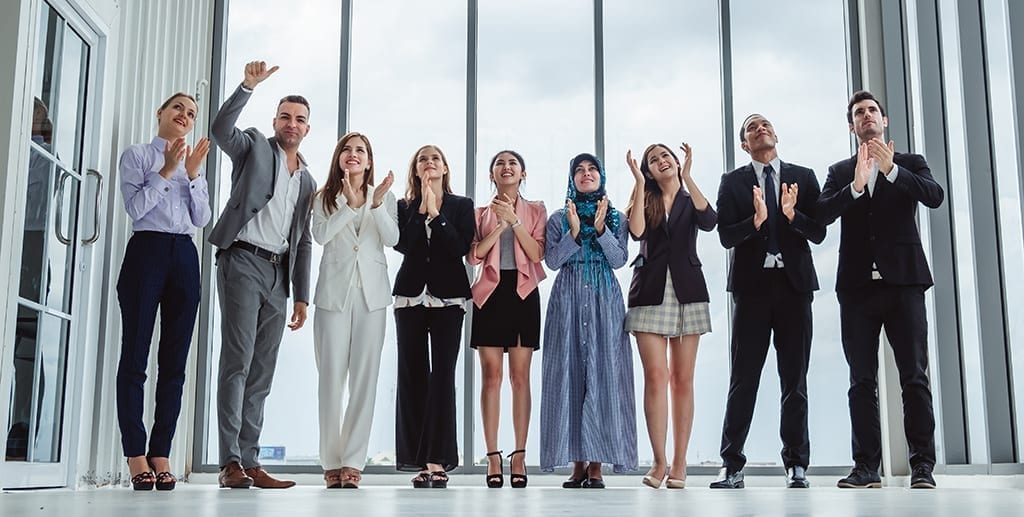 Group of diversity business people celebrating clapping hands for teamwork and successful
