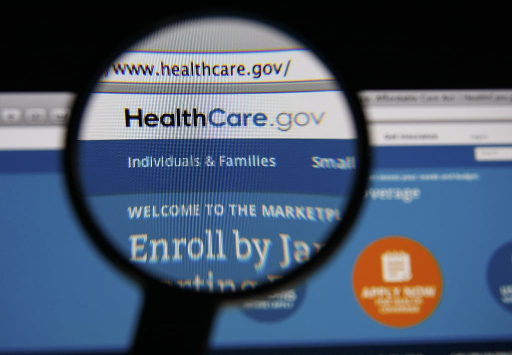 Photo of HealthCare.gov homepage on a monitor screen through a magnifying glass