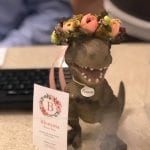 A California flower farmer and designer dressed up a toy dinosaur at her local bank to advertise her business. Toy Flower Crown Provides Fun,