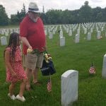 Gabrielle Miller and her father, Richard Miller, of Purcellville, Va., place flowers in section 54 at Arlington National Cemetery